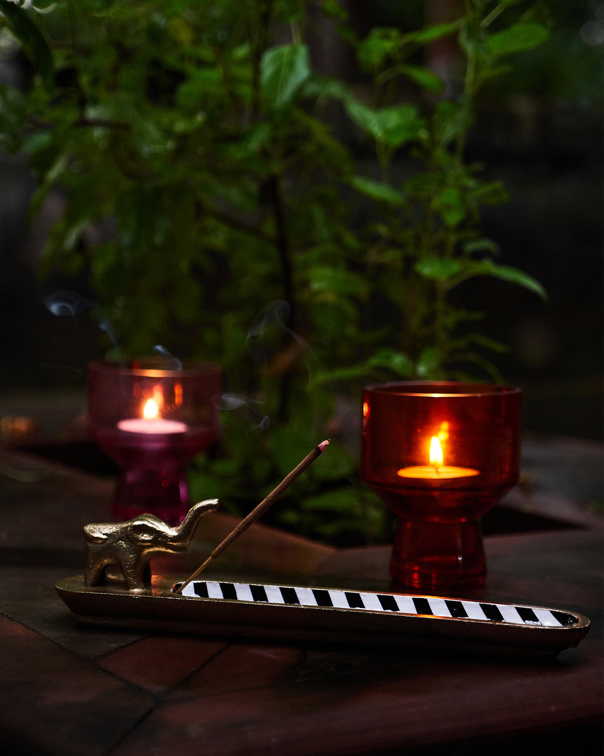 Brass Haathi incense holder with a striped tray and lit incense.