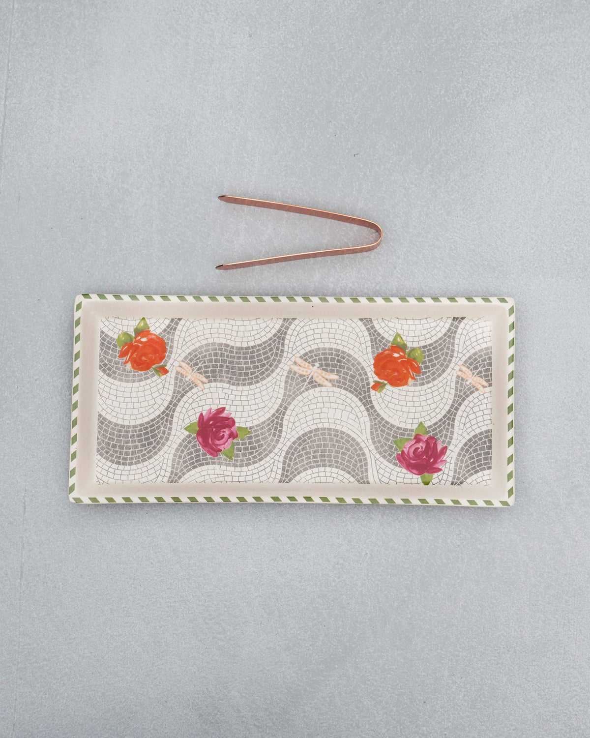 Mosaic Bloom cookie tray with rose motifs and copper tongs laid above it.