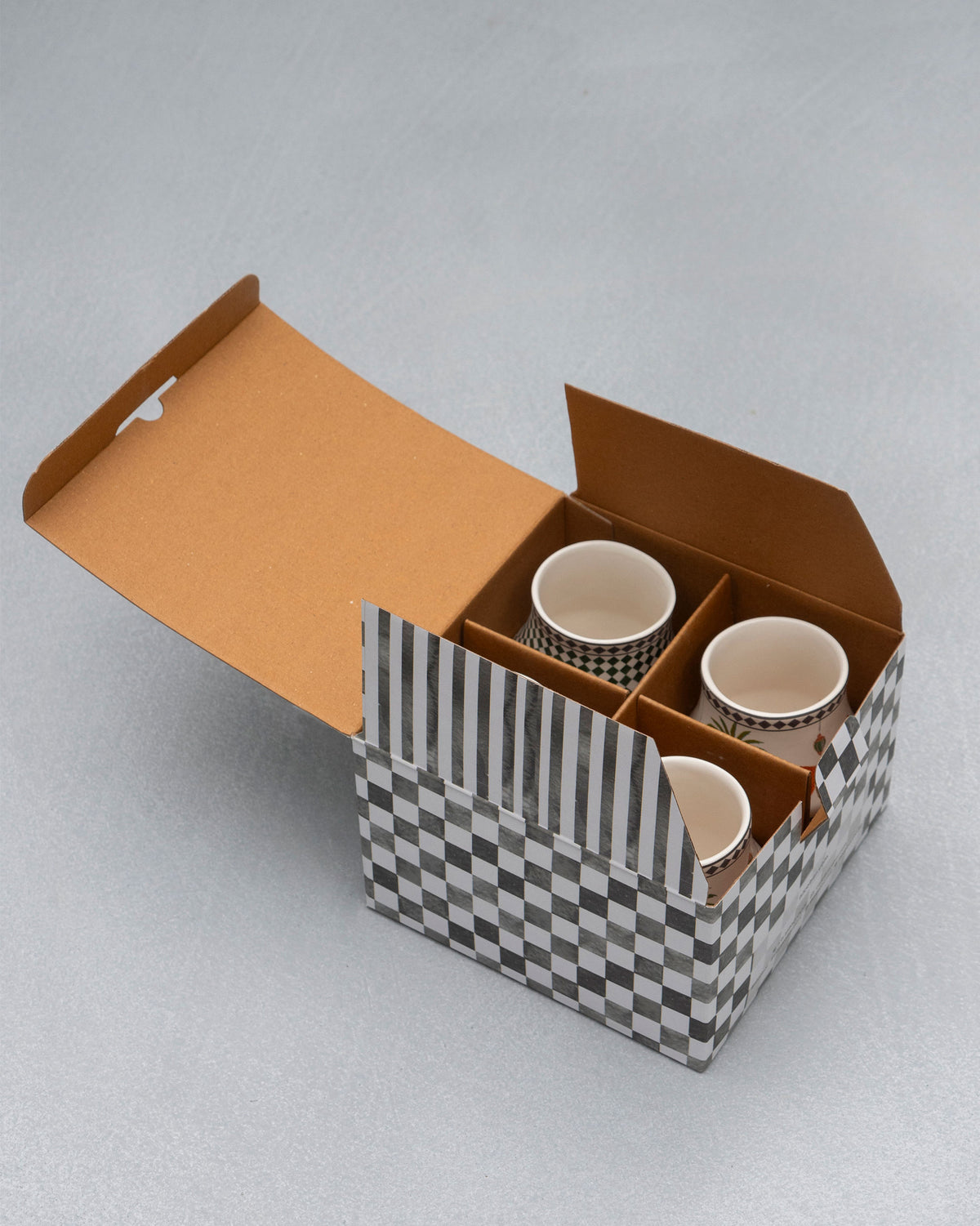 Dessert Palm Kulhars packed in an open checkered gift box with dividers.