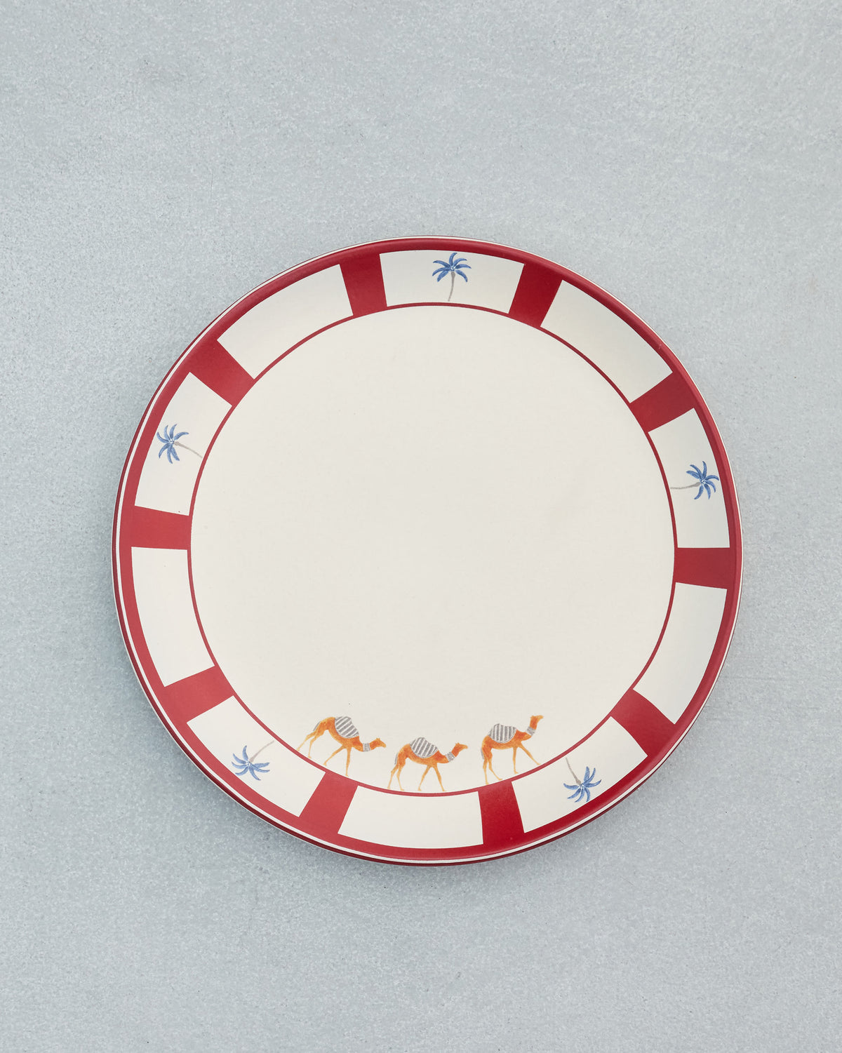 Desert Trail Dinner Plate with a red rim, camels and blue palm trees.