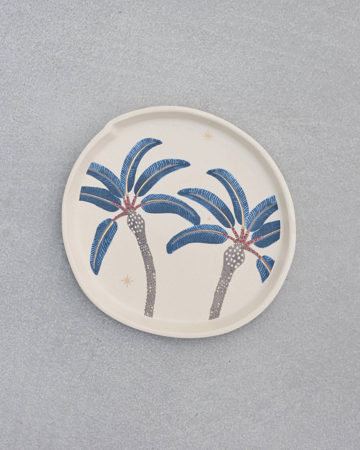 Dancing Palm Dessert Plate in cream with two blue palm trees, shown from above.