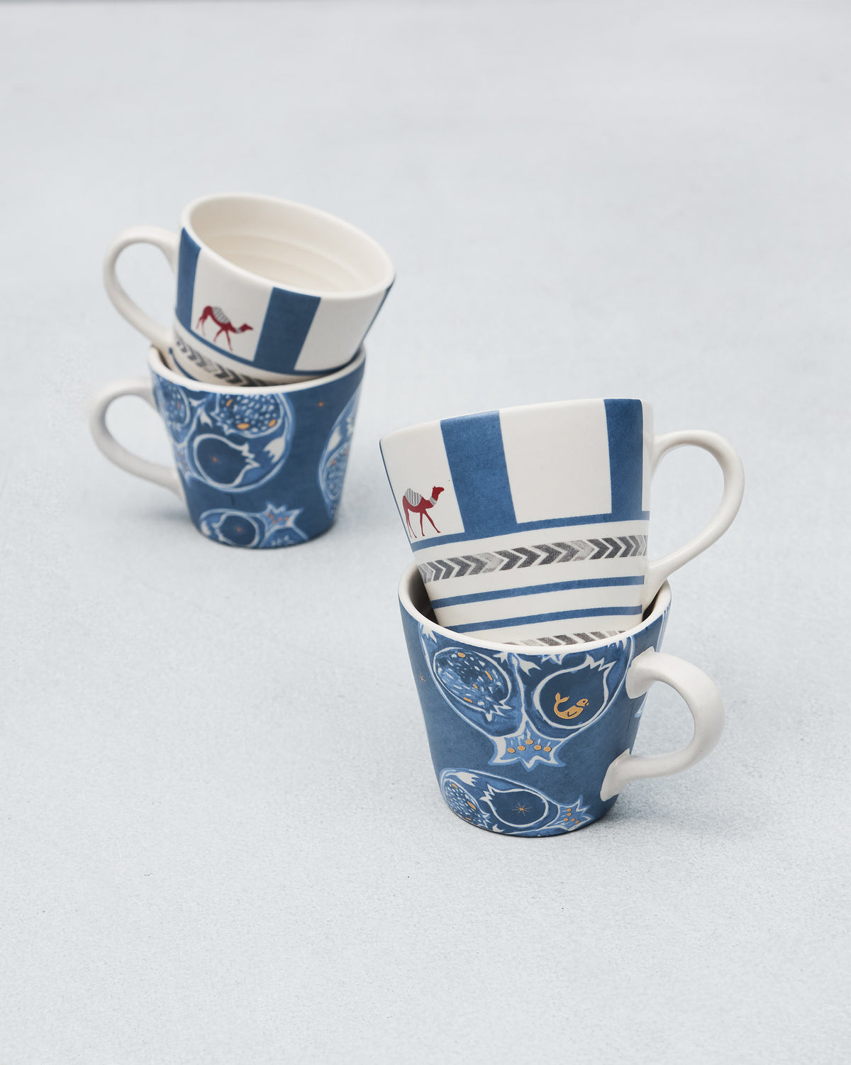 Stacked Desert Trail Espresso Mugs pairing camel stripes with pomegranate prints.