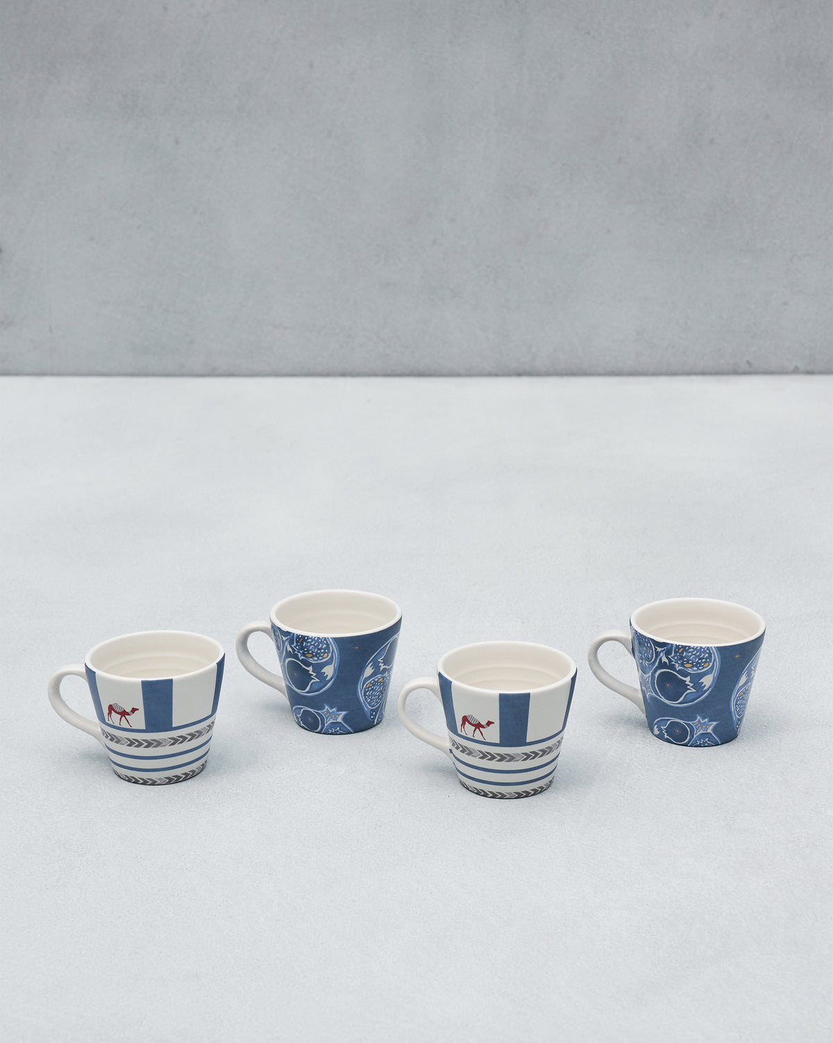 Four Desert Trail Espresso Mugs showing camel and pomegranate indigo designs.