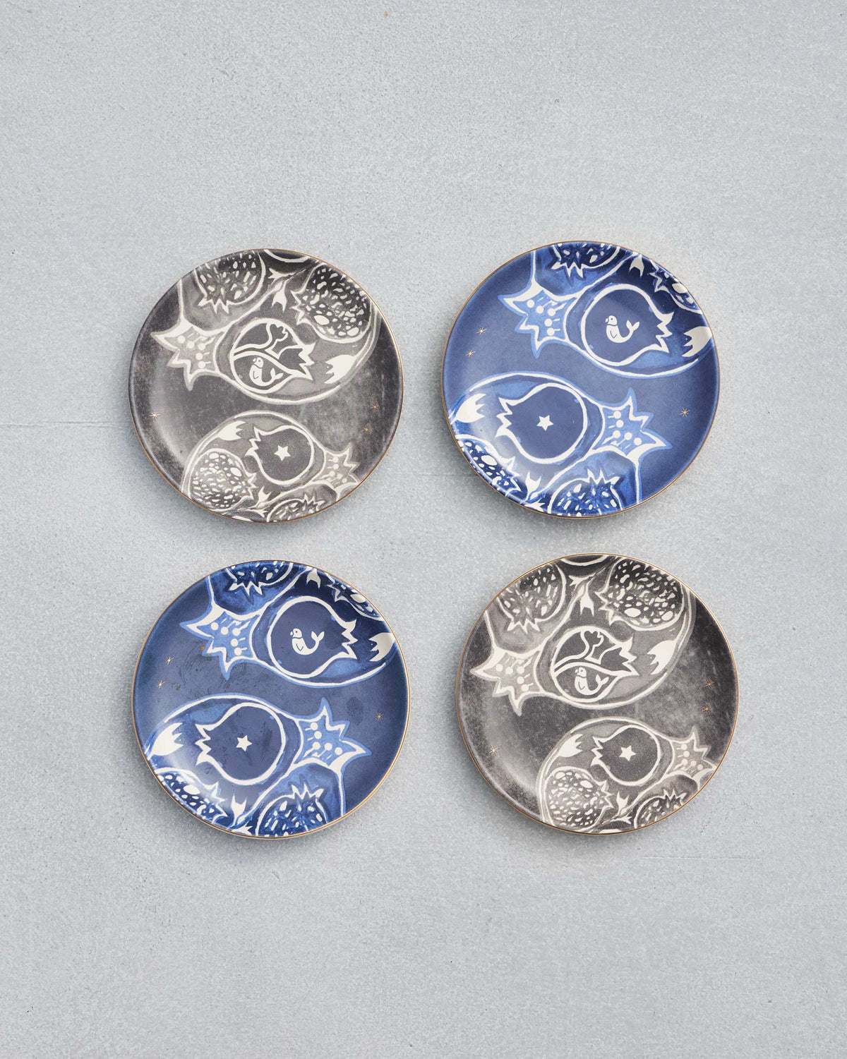 Set of four Desert Trail Tea Plates with white pomegranate motifs.