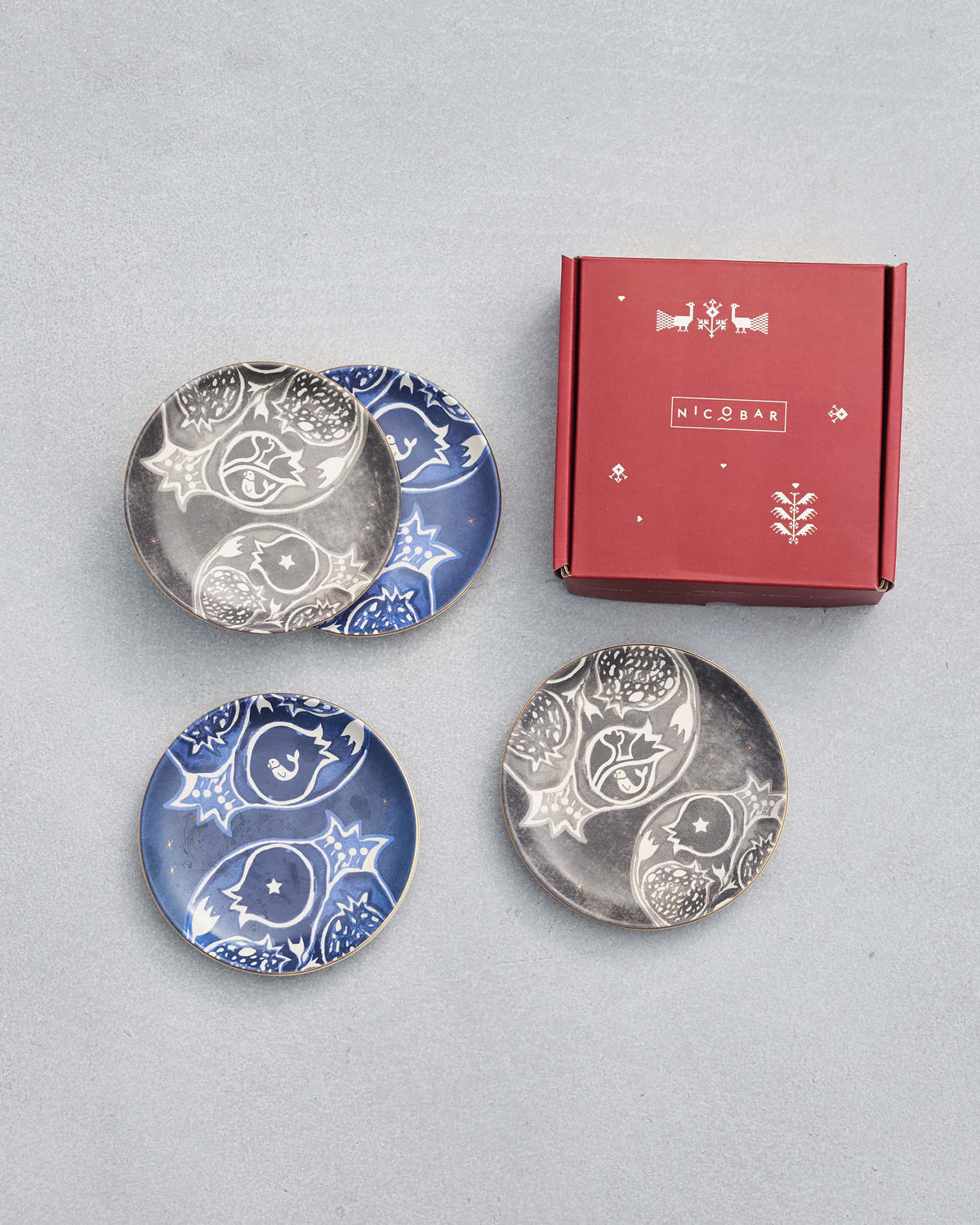 Desert Trail Tea Plates with pomegranate prints beside a Nicobar box.
