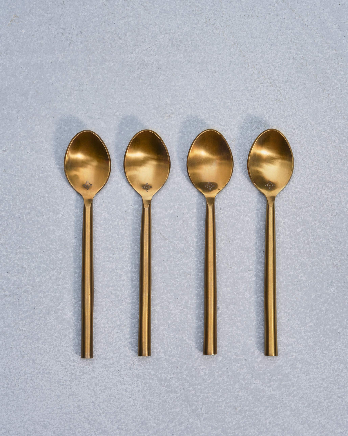 Set of four gold Sahara dessert spoons lined up in a row.