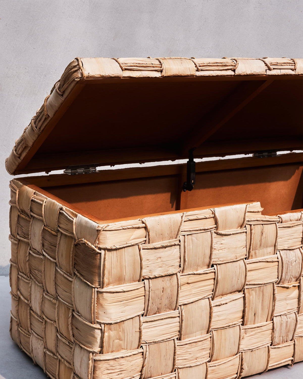 Open Mirage abaca trunk showing the lined interior and lid stay.