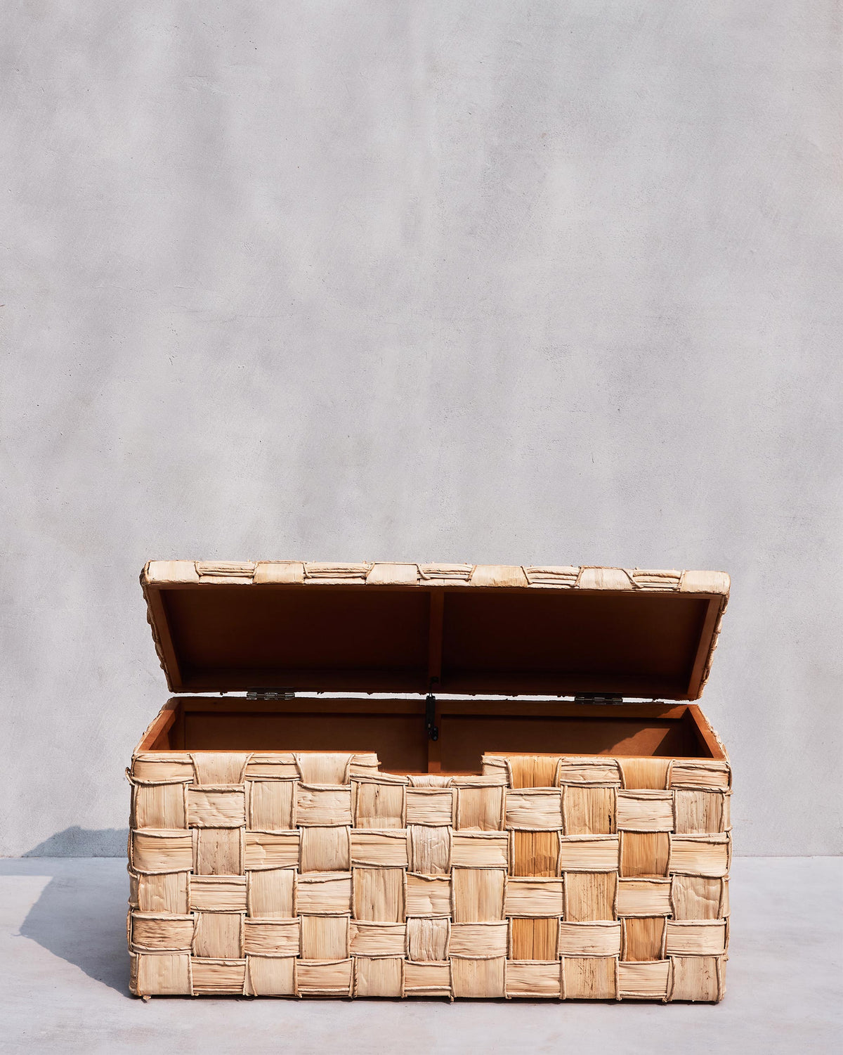 Front view of an open Mirage abaca trunk with brown interior lining.