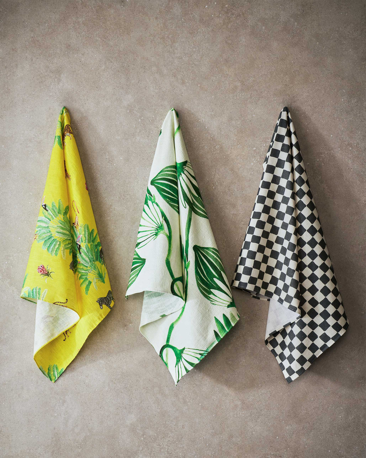 Three Fez fabric cloths in yellow, green leaf and checkerboard prints.