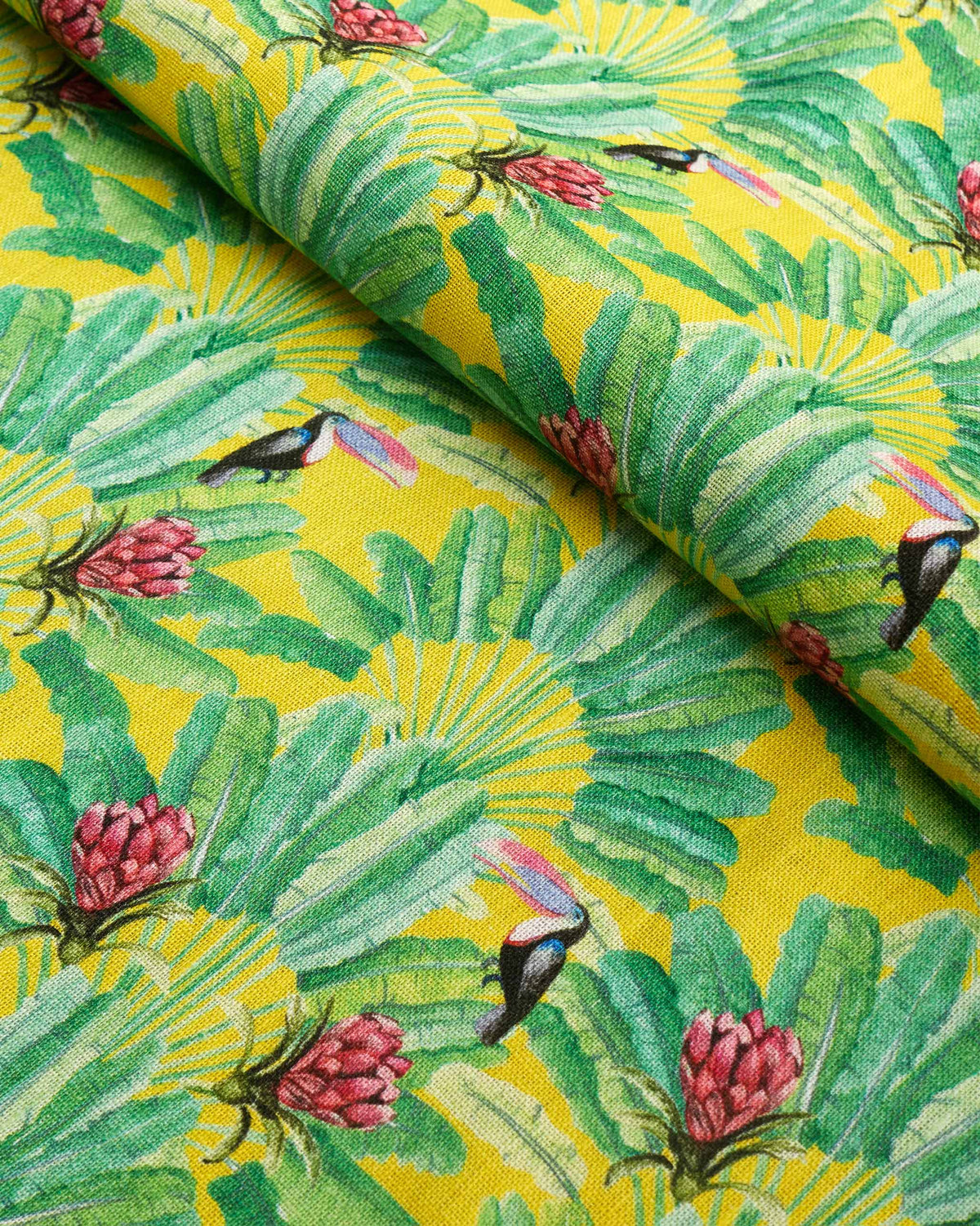 Lemur Yellow fabric with toucans, red flowers and green leaves on yellow.
