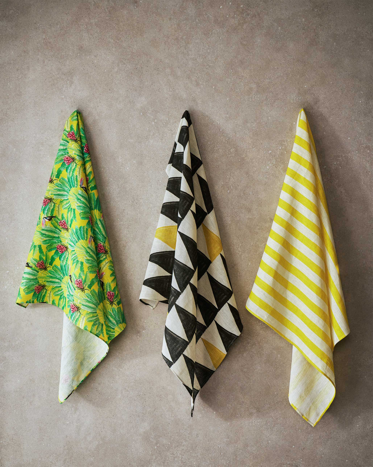Three hanging fabrics in tropical, triangle and yellow stripe prints.