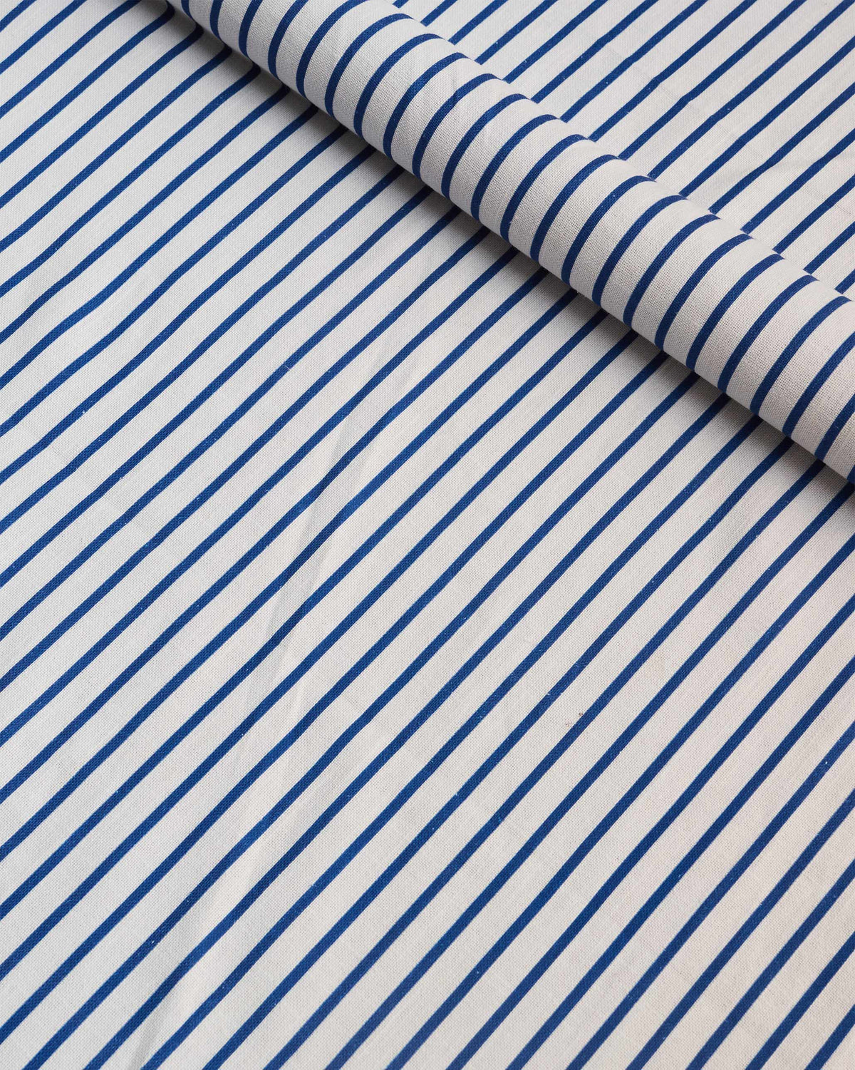 Blue Pinstripes fabric rolled to show navy stripes on white.