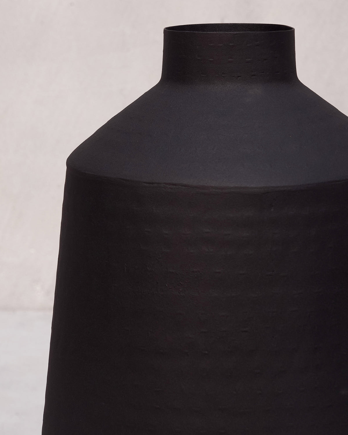 Close-up of a black Dhara vase neck and textured shoulder.