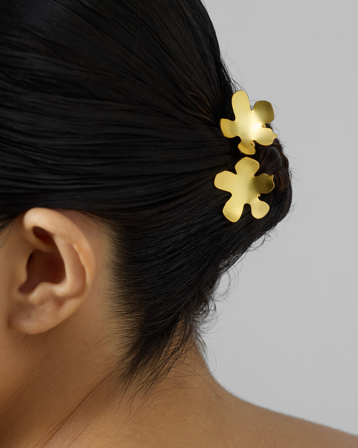 Gold Small Poppy hairpins worn in a dark updo.