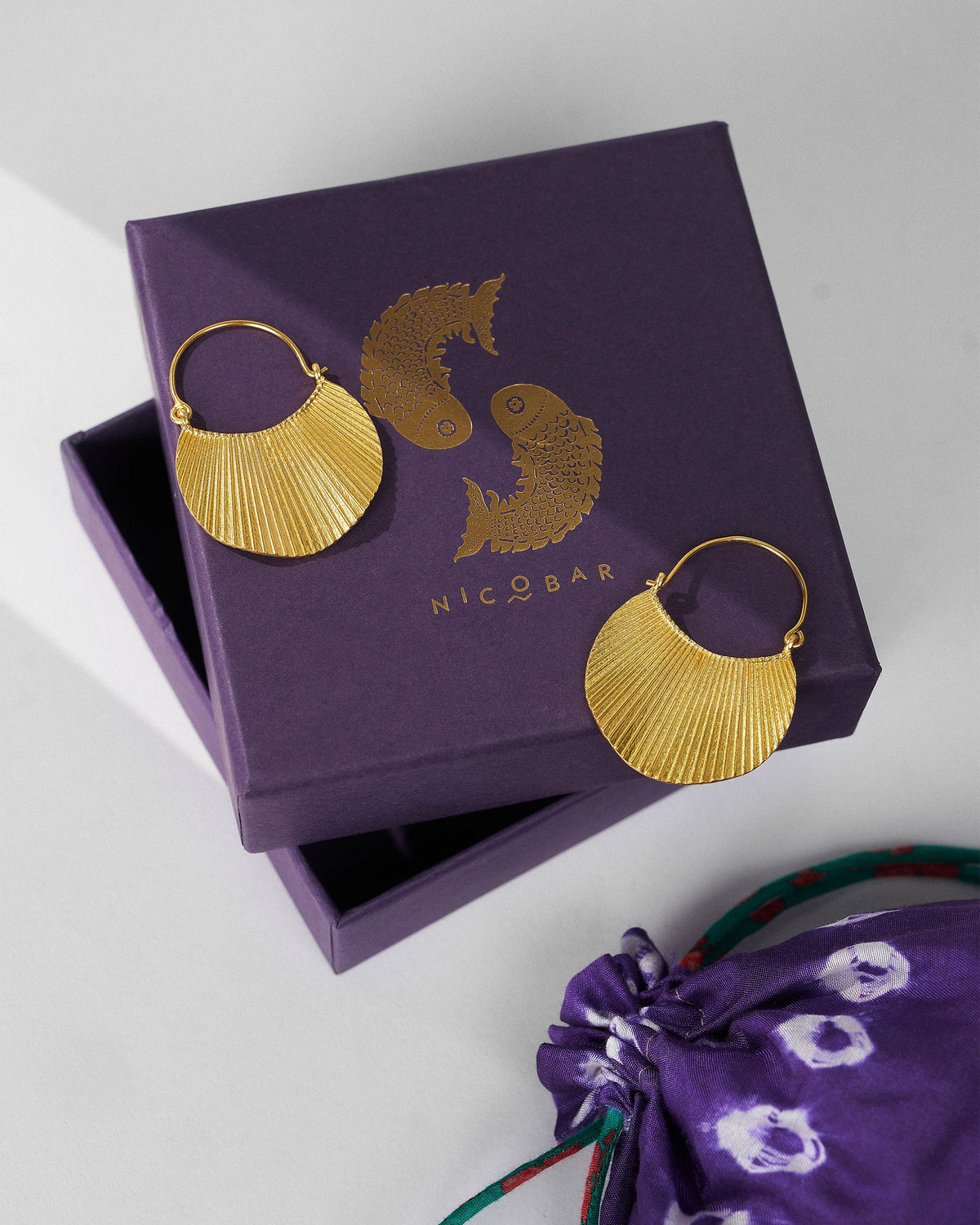 Gold Pankha fan balis on a purple Nicobar gift box.