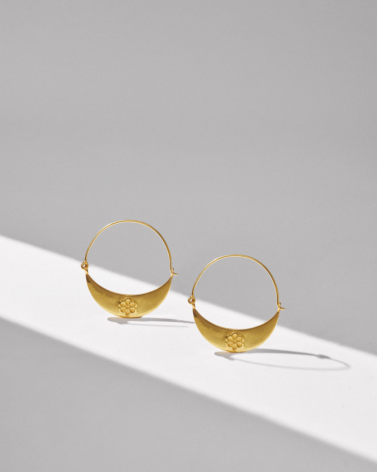 Pair of gold Boat balis with crescent plates and small flower motifs.