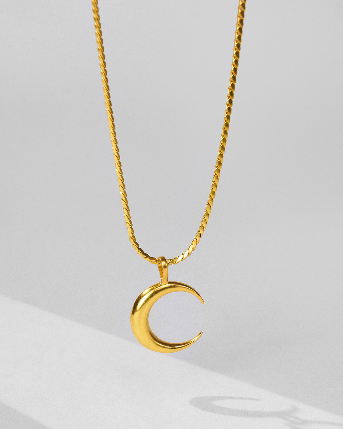 Gold crescent Moonfall pendant on a rope-style chain.