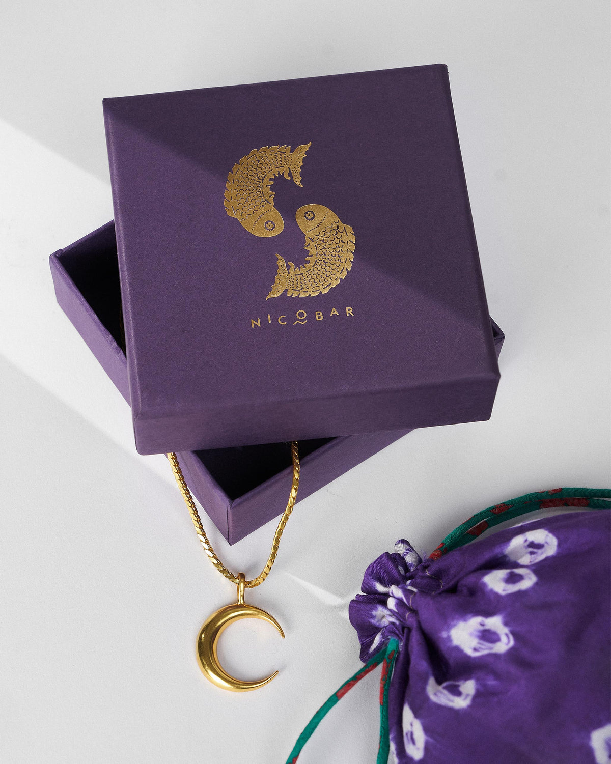 Gold Moonfall necklace on a purple Nicobar gift box.