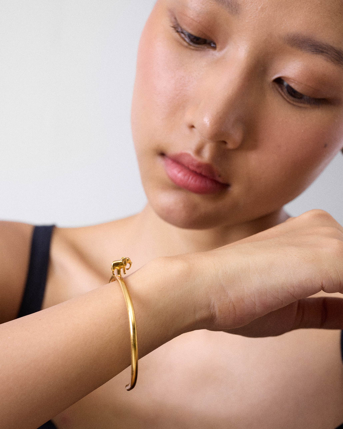 Gold haathi cuff with a small elephant charm worn on a wrist.