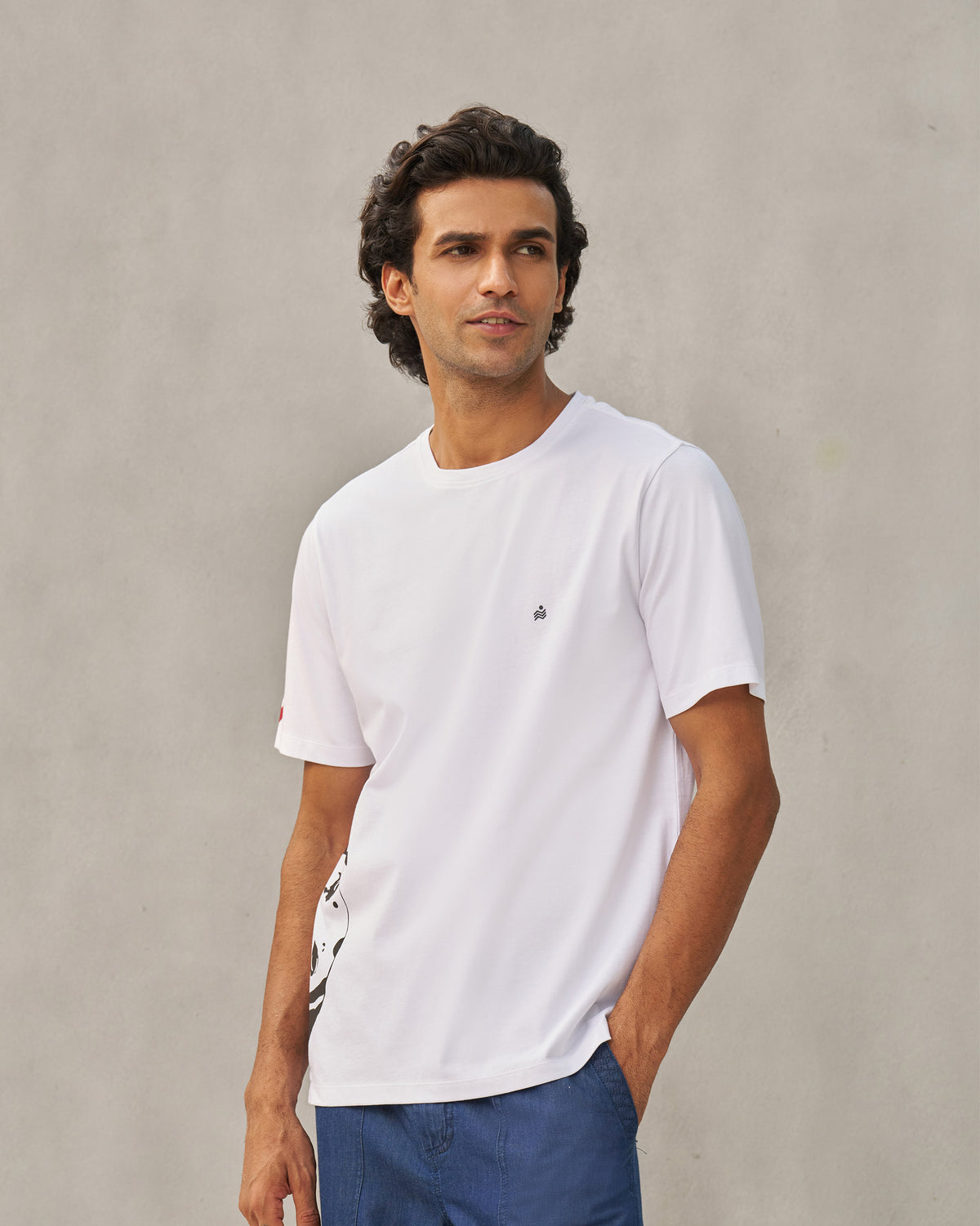 Person wearing a white Peekaboo Dalmation T-shirt with a small chest motif.