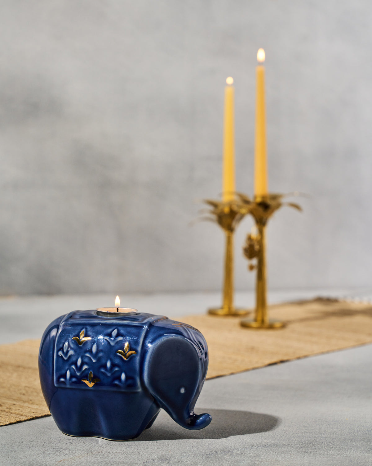 Blue Tusker elephant votive with a lit tealight and gold accents.