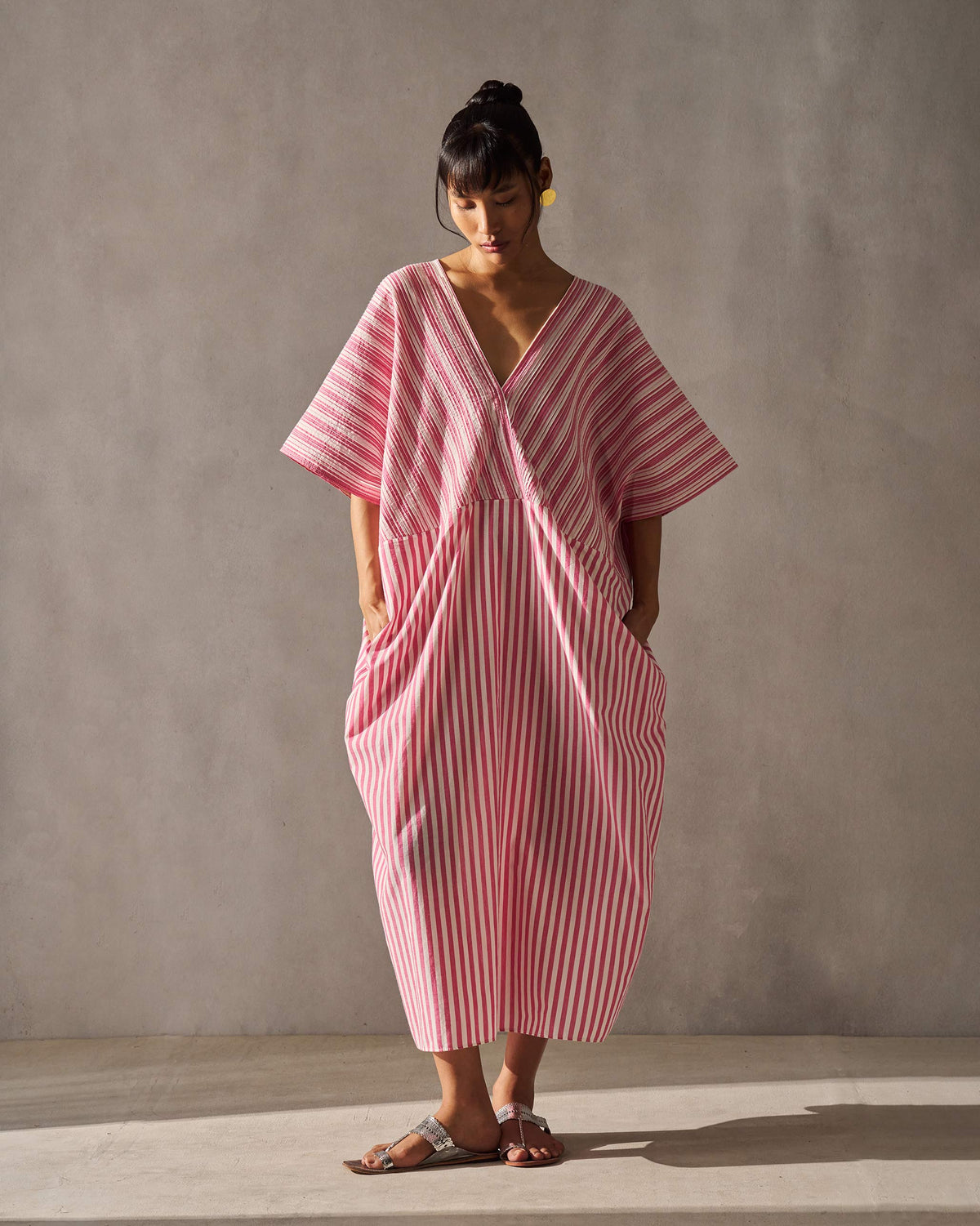 Full-length front view of a Sarai Kaftan with a pleated V-front and side pockets.