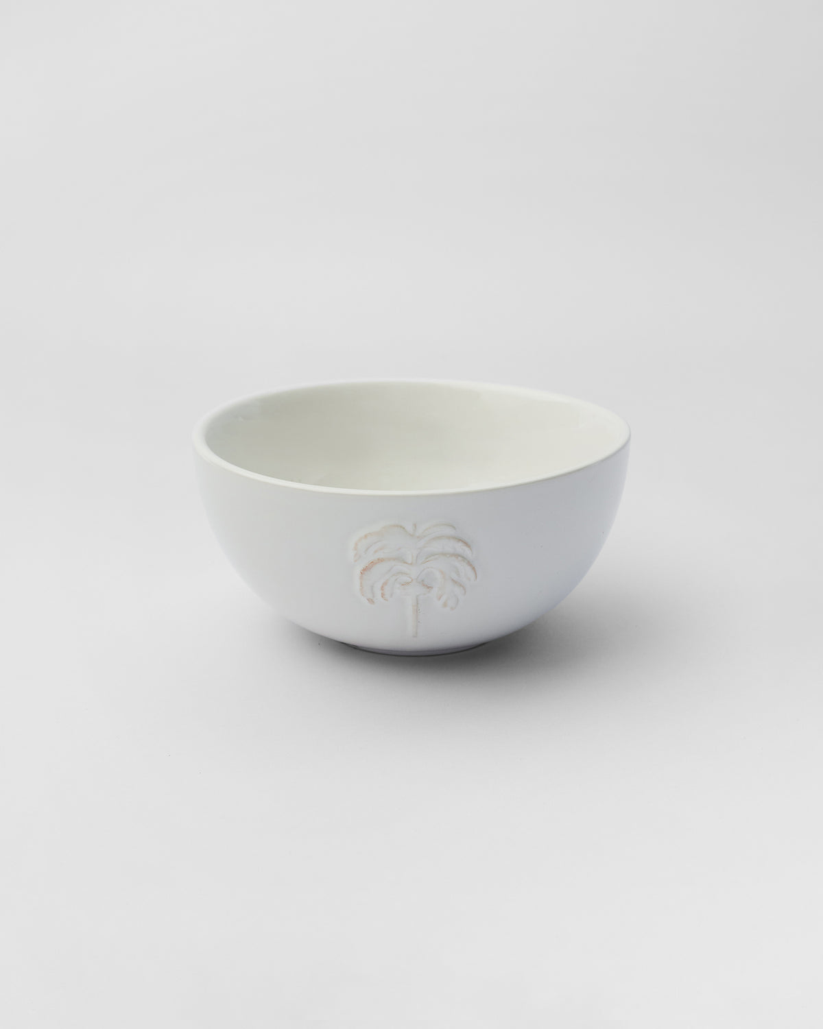 Ele Palm Cereal Bowl in white with an embossed palm tree on its side.