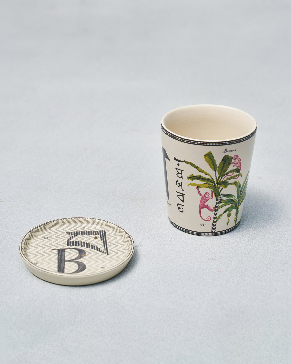 Alphabet cup with banana tree and monkeys beside a letter B coaster.