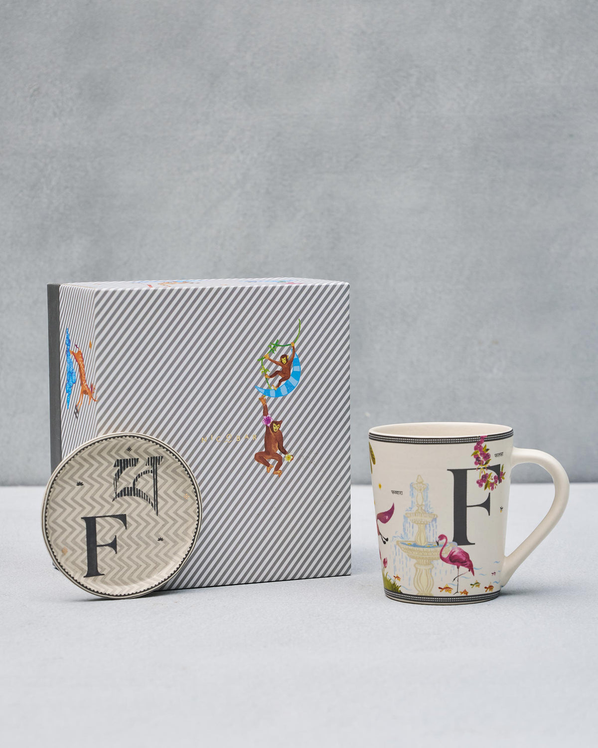 F Alphabet mug and coaster with letter F motifs beside a striped Nicobar gift box.