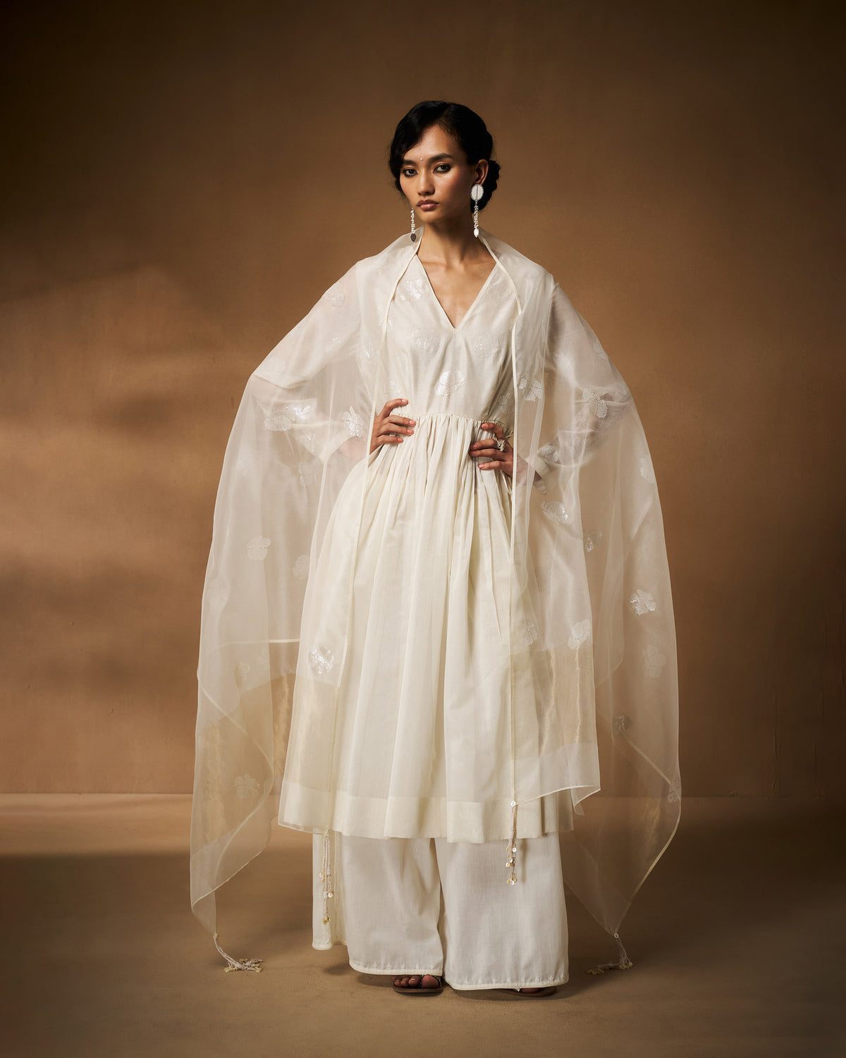 Person wearing an ivory Amaya kurta with a sheer embroidered dupatta.