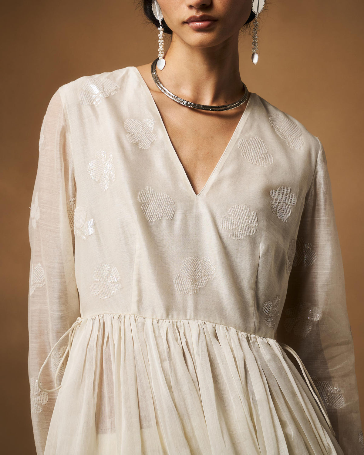 Close-up of the V-neck and floral embroidery on an ivory Amaya kurta.