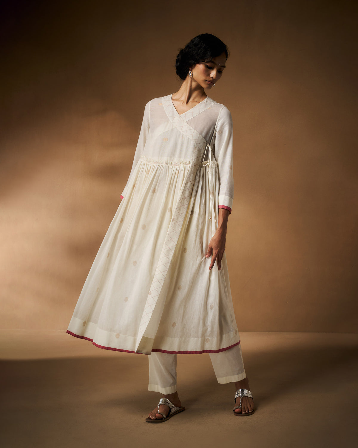 Person wearing an ivory Sukoon angrakha with a deep wrap V neckline.