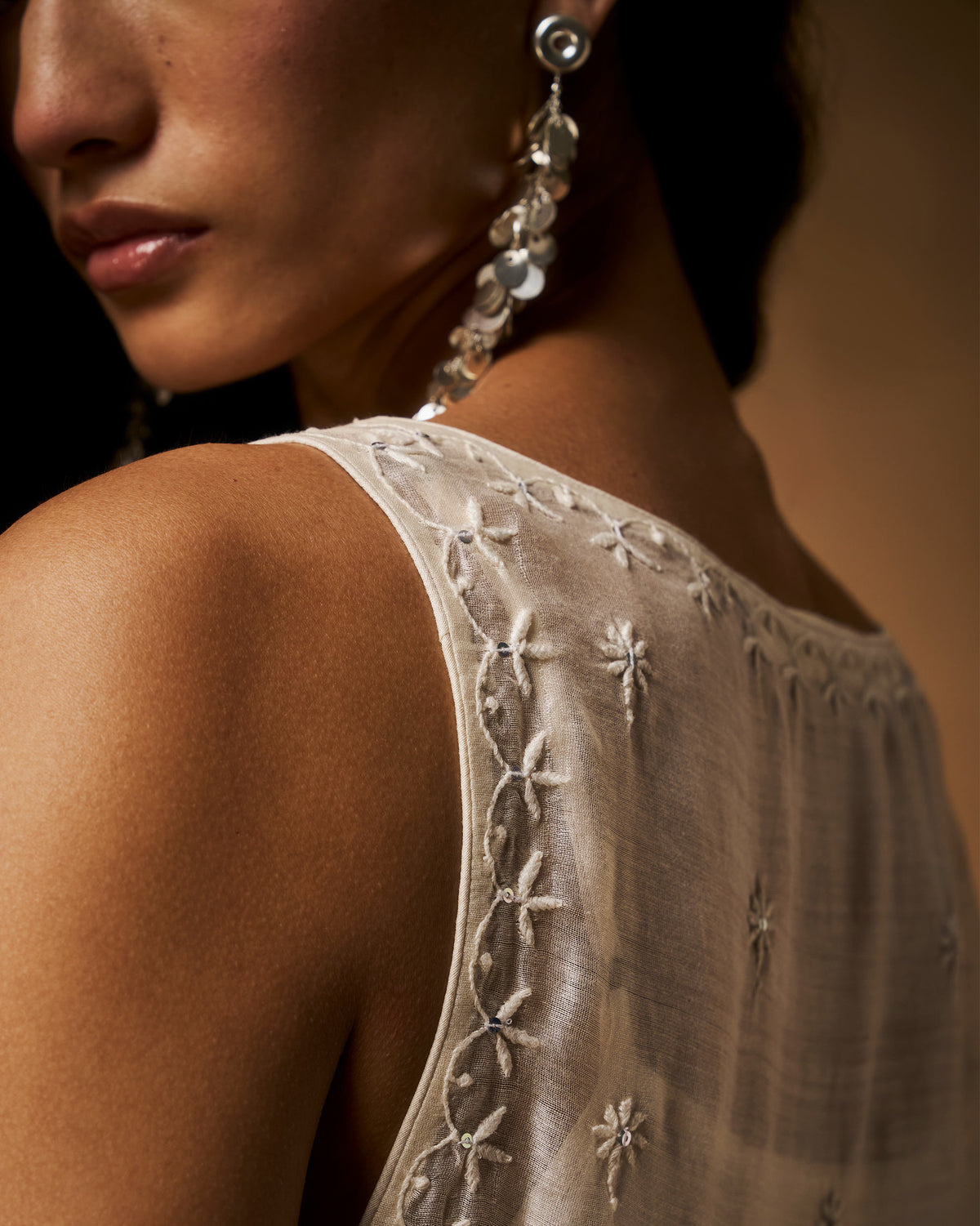 Close-up of scalloped chikankari and sequins on an ivory Afra tunic shoulder.