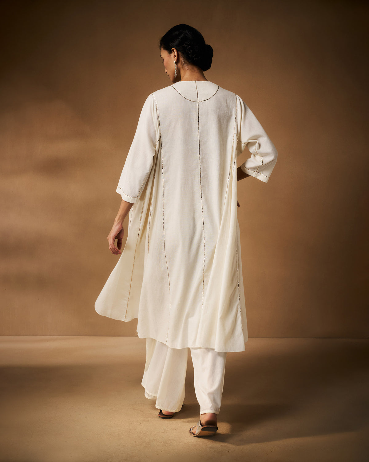 Back of an ivory Aheli Kurta with vertical silver embroidered lines.