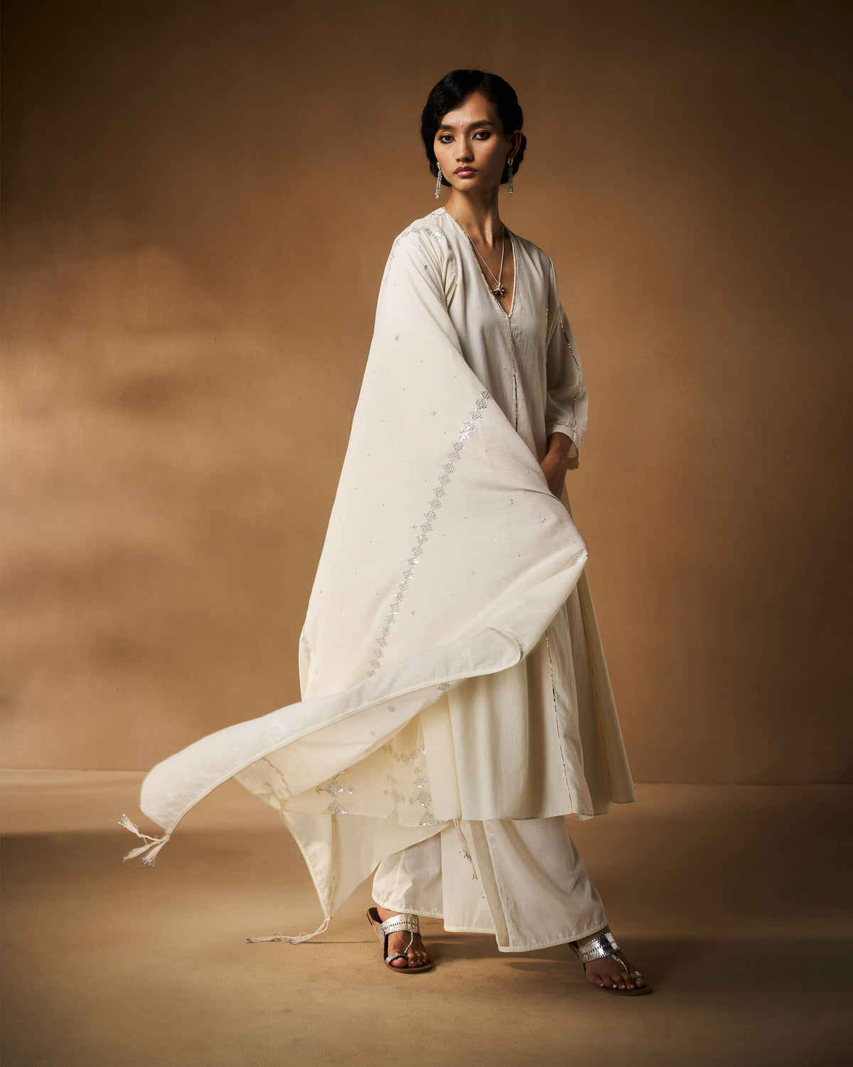 Person wearing an ivory Aheli Kurta with a silver-embroidered dupatta.