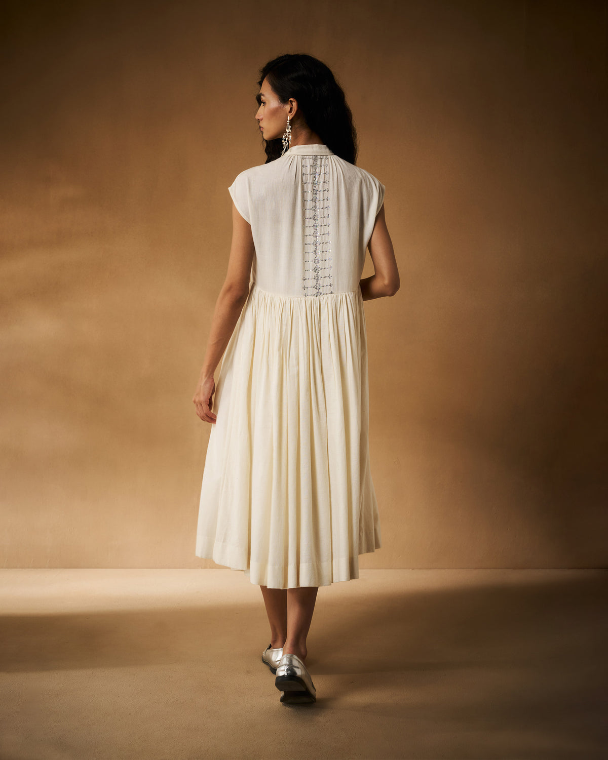 Back of an ivory Mina Dress with a sequin panel and flared skirt.