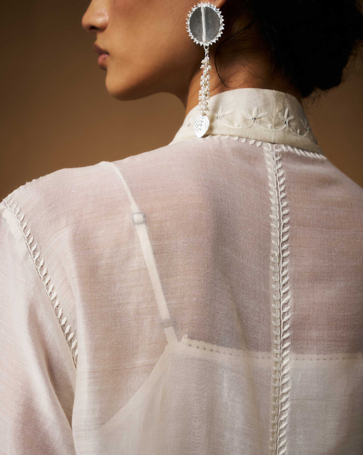 Close-up of the ivory Pavi overlay back collar with white embroidery.