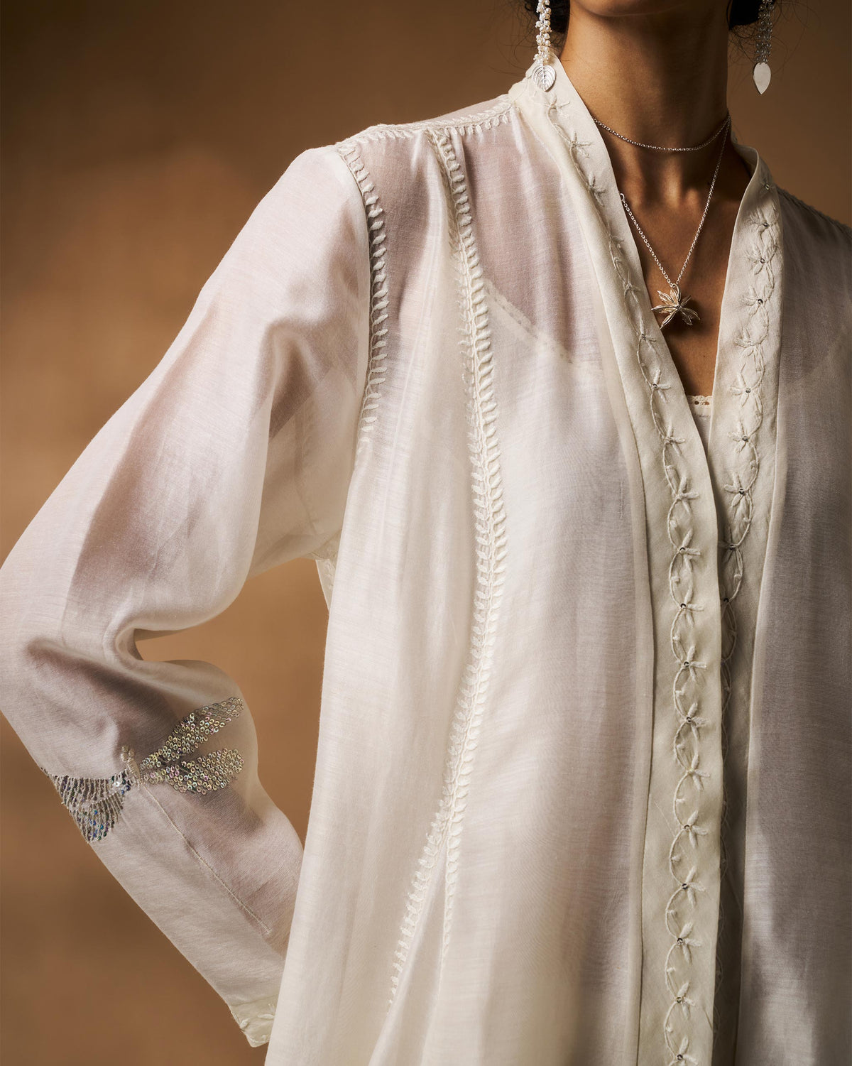 Side view of an ivory Pavi overlay with a silver dragonfly on the sleeve.