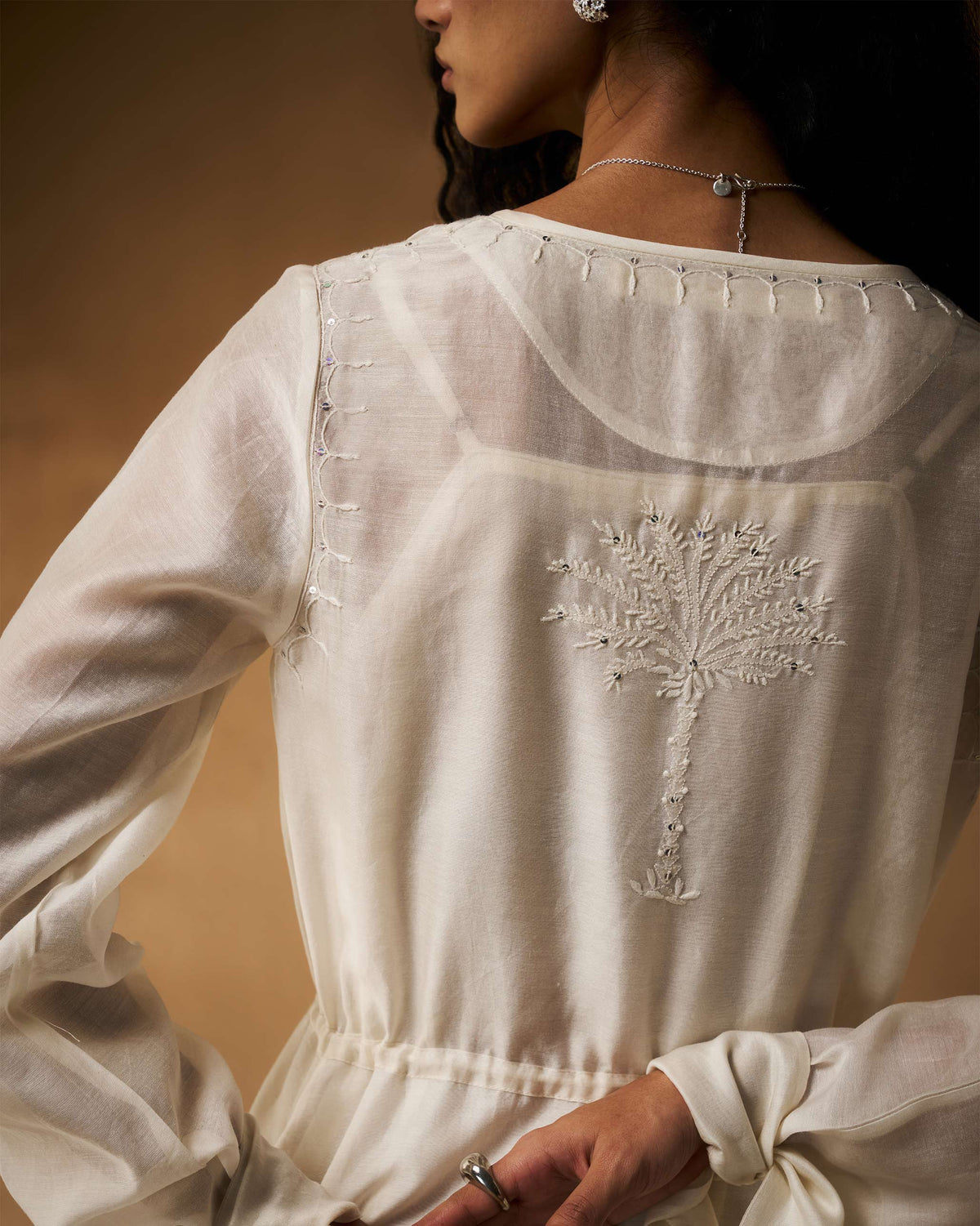 Back of an ivory Nazaha overlay with a palm tree embroidery.