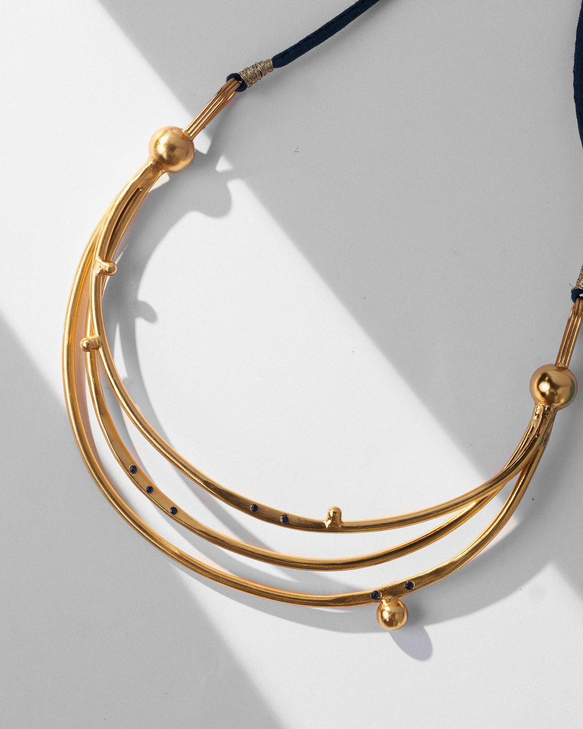 Close-up of the gold Celestial choker’s triple crescent bars.