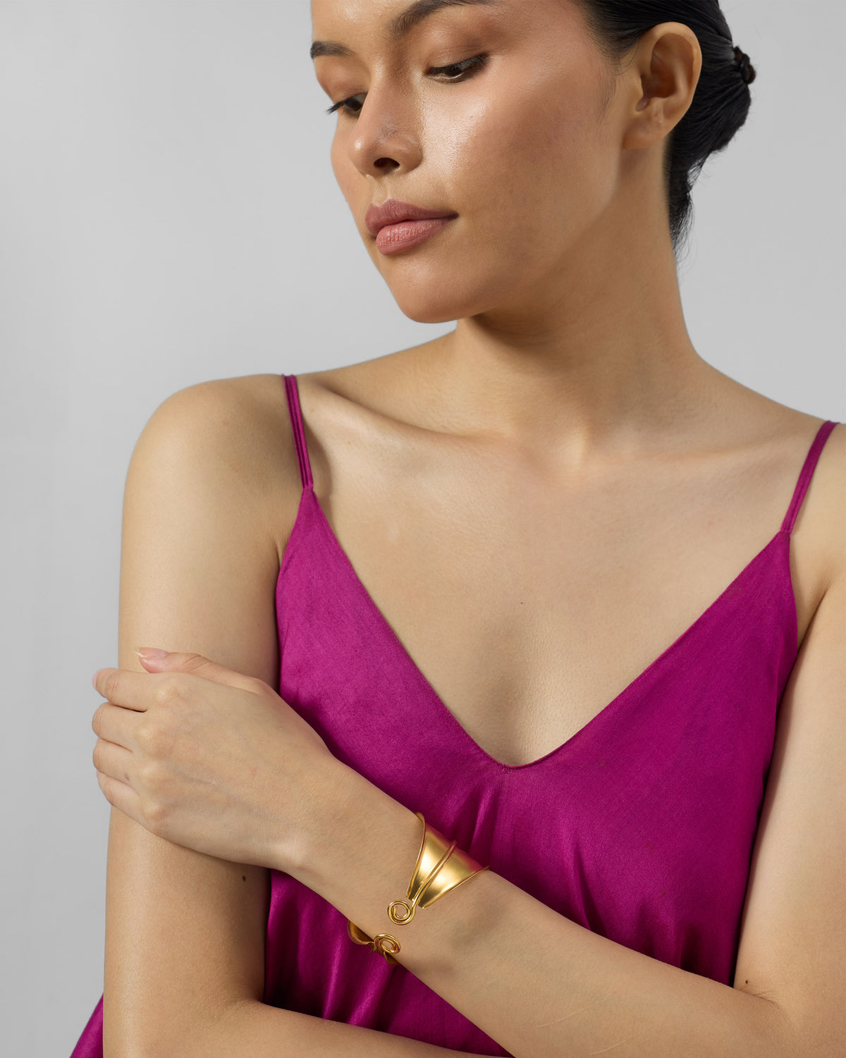 Person wearing a gold rays cuff on a wrist.