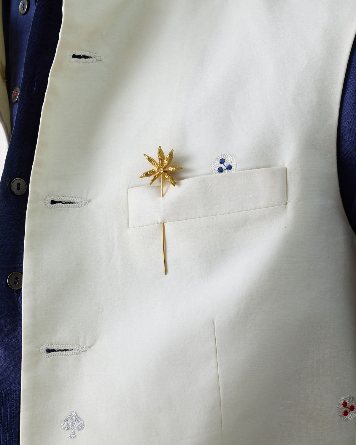 Star Anise Lapel Pin pinned to a white vest pocket.