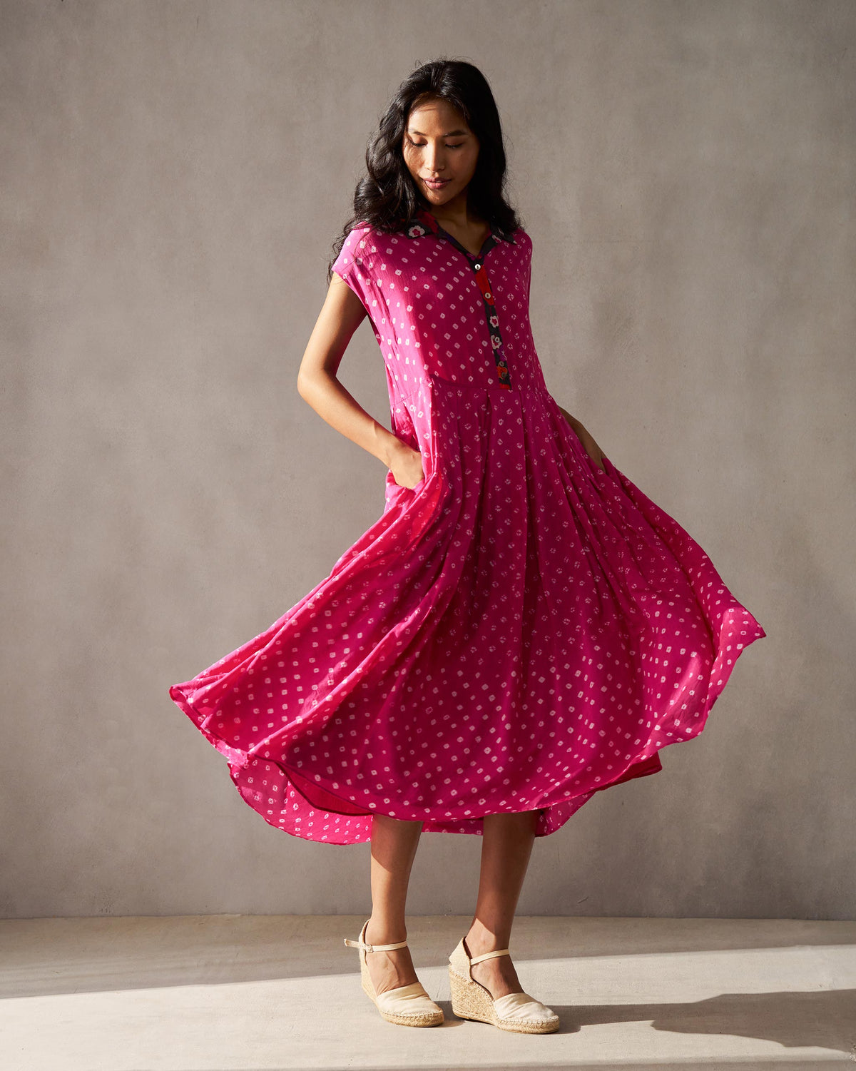 Person wearing a fuchsia Midsummer dress with a flared skirt and pockets.