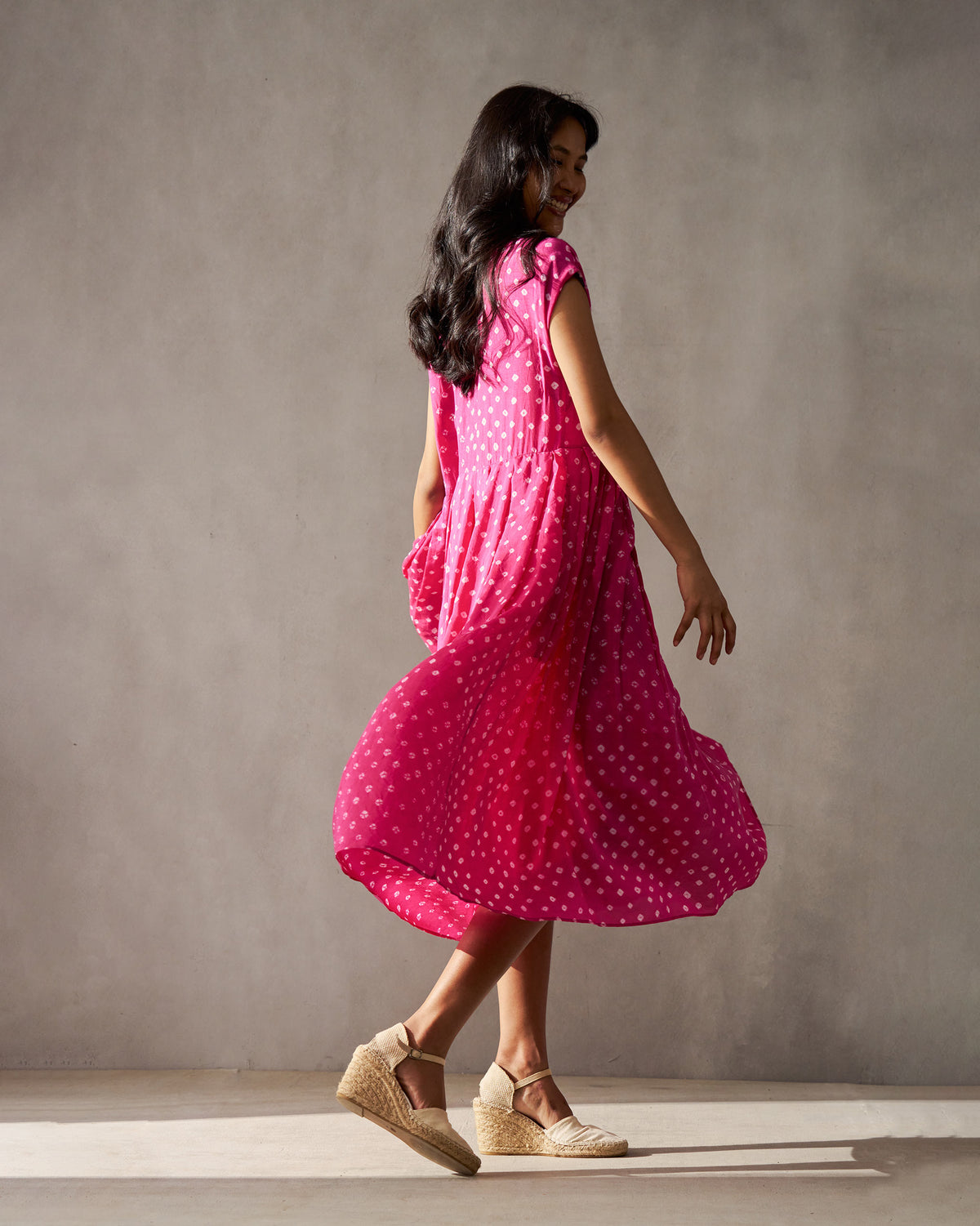 Side view of a fuchsia Midsummer dress with a flared skirt in motion.