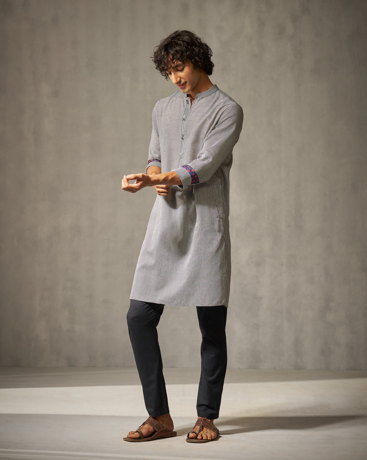 Person wearing a striped Revel Kurta with navy patterned cuff lining.