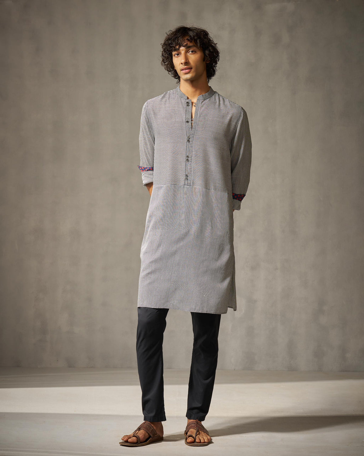 Person wearing a black and ivory striped Revel Kurta with rolled sleeves.