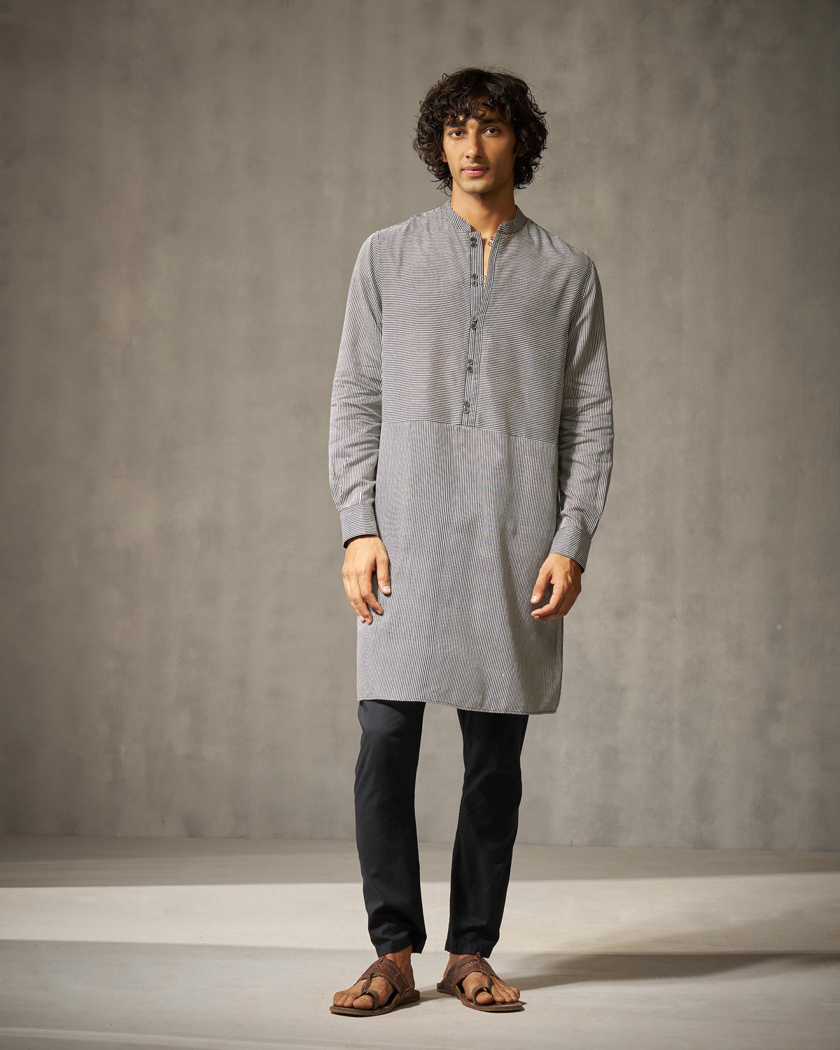 Person wearing a black and ivory striped Revel Kurta with full sleeves.