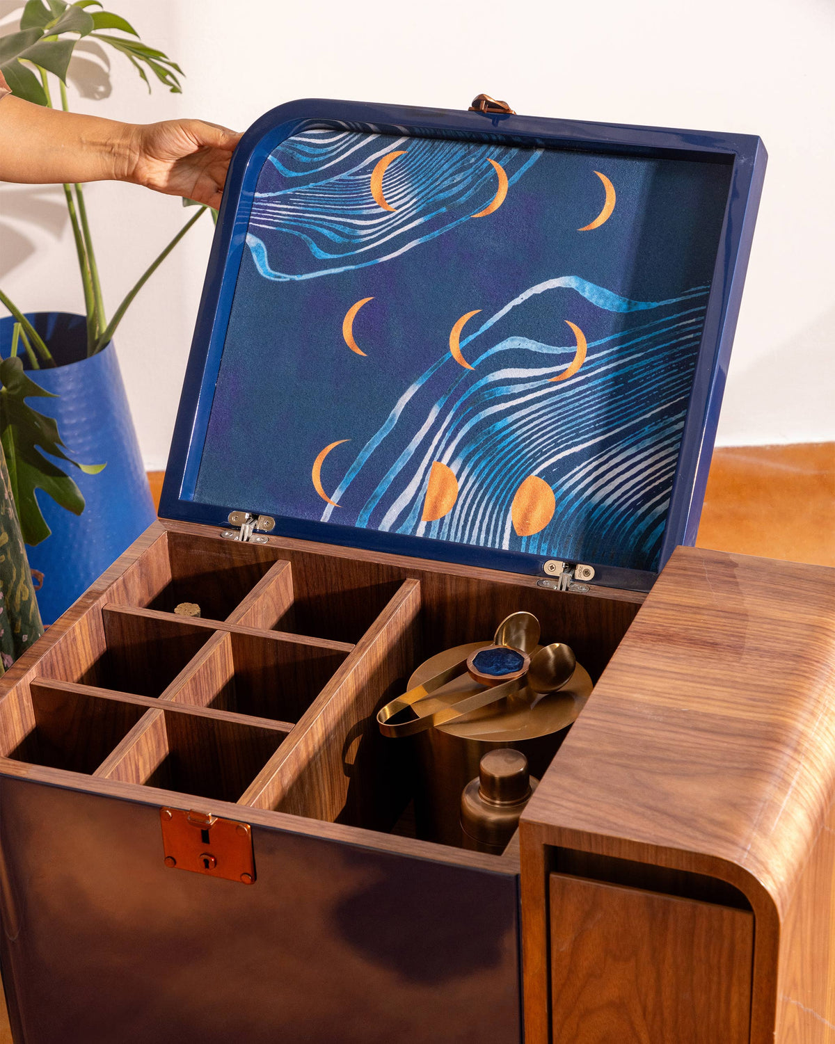 Open Contours of Time bar trolley showing bottle cubbies and a moon-pattern lid.