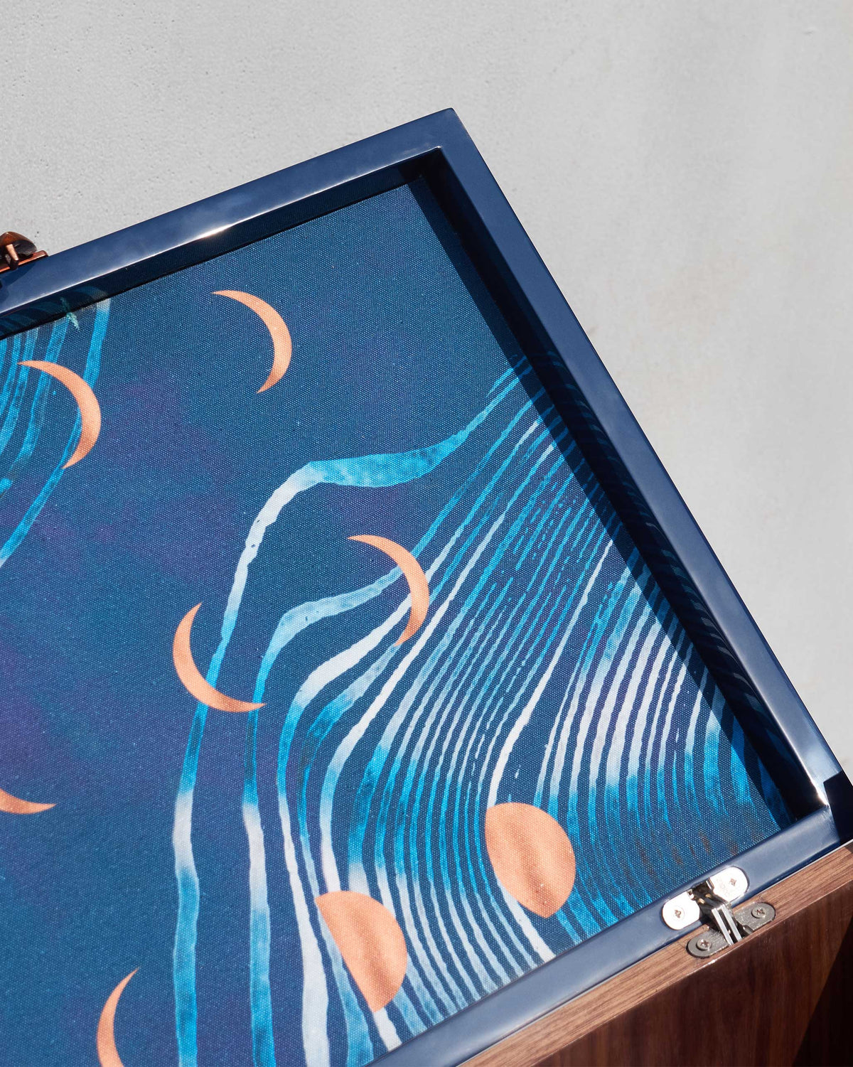 Close-up of the Contours of Time lid lining with crescent moons and waves.