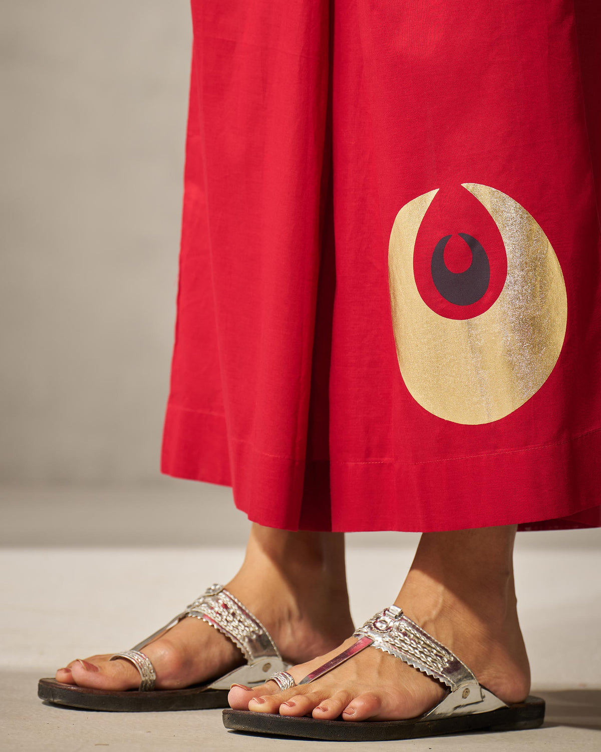 Close-up of the gold circle motif on red Basic pyjamas.